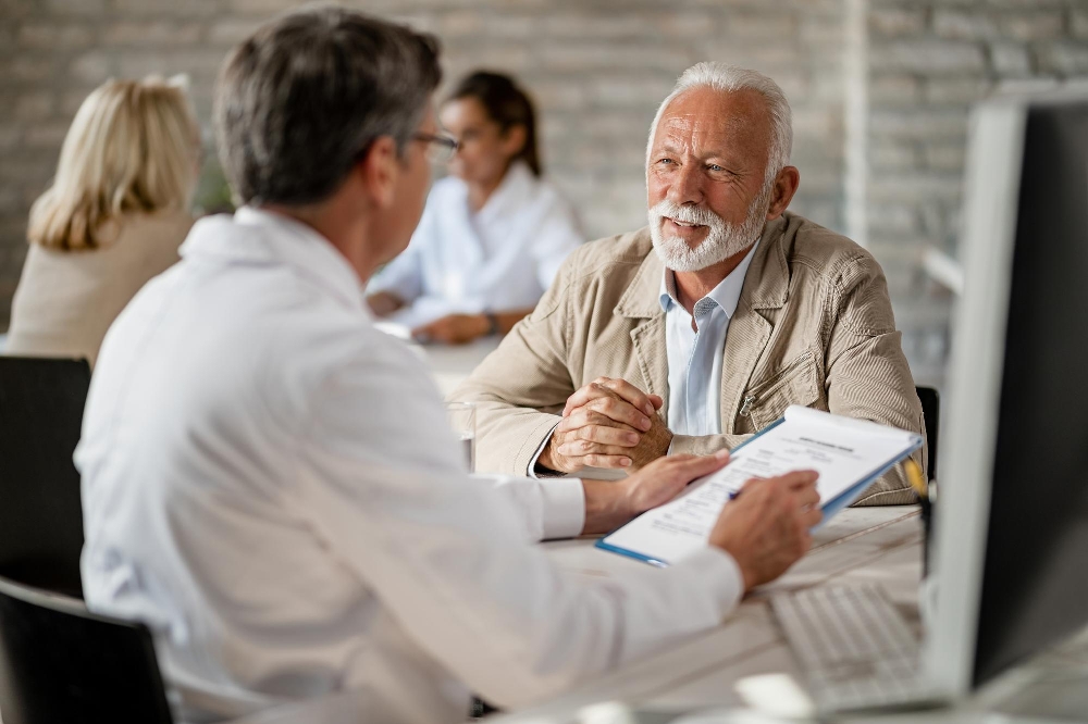 A mature man in a consultation with his doctor about a health insurance policy.